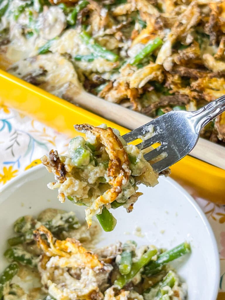 Homemade green bean casserole topped with golden crispy fried onions in a baking dish, the perfect Thanksgiving side dish made from scratch