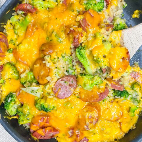 Skillet Kielbasa is an easy, full meal made in one pan and ready in just 30 minutes. It's made with rice, kielbasa, chicken broth, broccoli, and topped with cheddar cheese. Perfect for a busy weeknight.