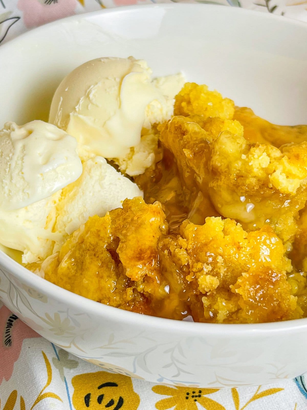 You'll love this Crock Pot Peach Cobbler because it's only 3 simple ingredients, it's the perfect dessert for any occasion, and it's a cinch to put together. This crock pot peach cobbler is my go-to dessert for a potluck for family gathering when I'm short on time. It's only 3 ingredients! The ingredients are peach pie filling, yellow cake mix, and butter. That's it! It takes literally 5 minutes to prep, it's inexpensive to make and it feeds a lot of people.