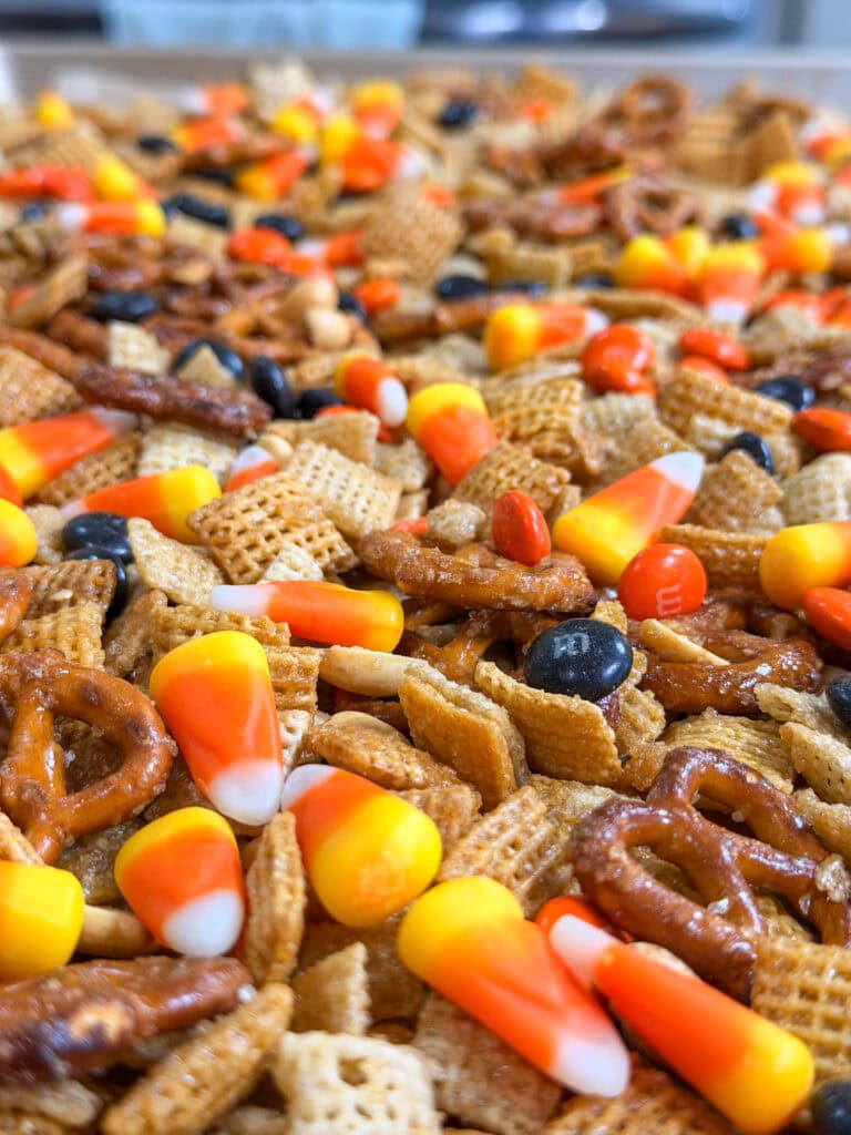 A close-up of Monster Mix, featuring a snack blend with candy corn, pretzels, Chex cereal, and colorful chocolate candies.