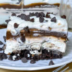 This Chocolate Lasagna dessert with a brownie crust is the ultimate chocolate lover's treat! It has a layer of rich fudgy brownie, a tangy cream cheese layer, a cool and creamy chocolate pudding layer and is topped off with whipped cream and mini chocolate chips. Perfect for a party, potluck, or get-together!