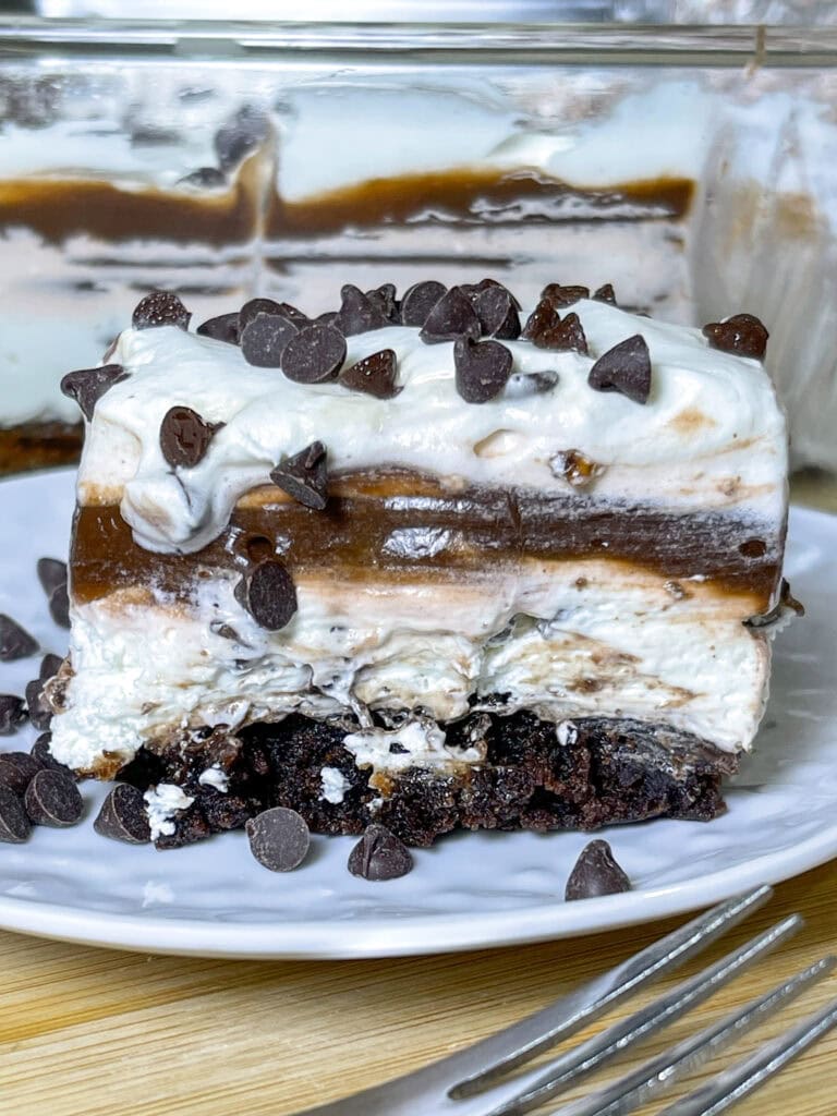 This Chocolate Lasagna dessert with a brownie crust is the ultimate chocolate lover's treat! It has a layer of rich fudgy brownie, a tangy cream cheese layer, a cool and creamy chocolate pudding layer and is topped off with whipped cream and mini chocolate chips. Perfect for a party, potluck, or get-together!