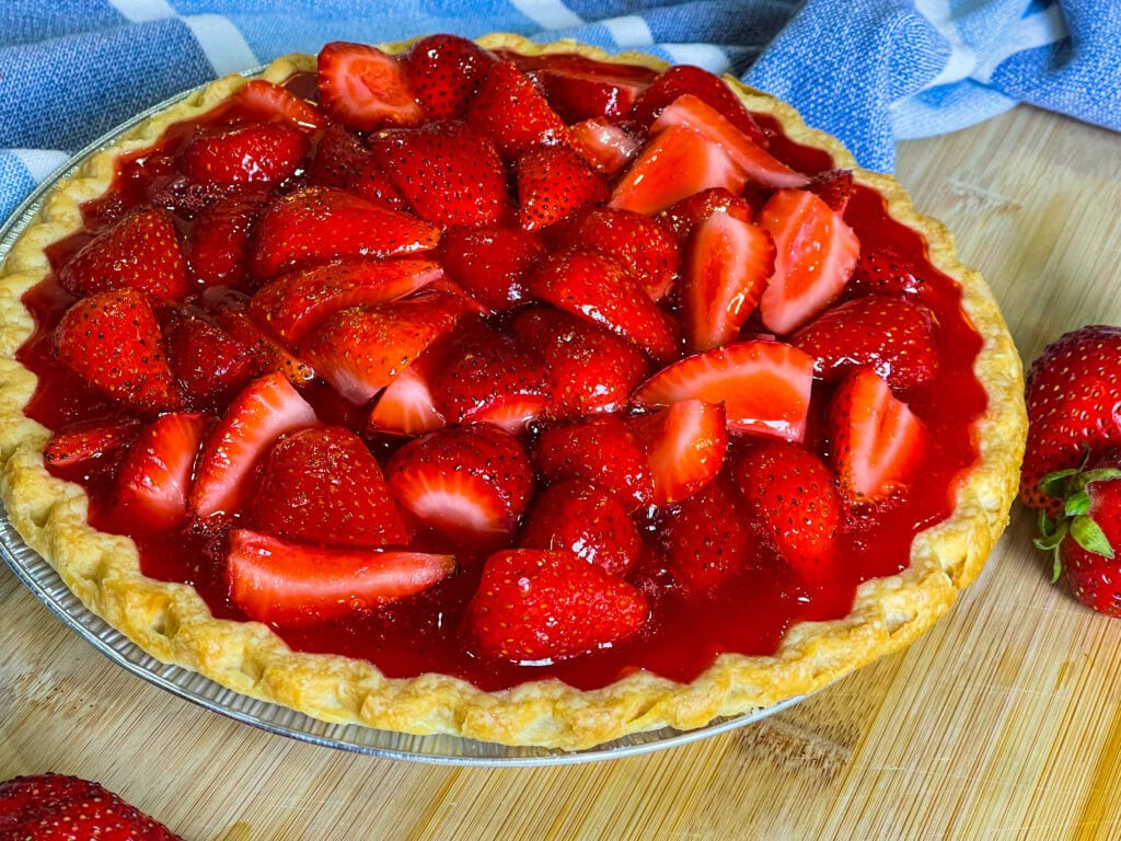 strawberry pie made with a store bought pie crust, fresh strawberries and a homemade strawberry glaze topped with whipped cream.