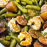 Close-up of shrimp and sausage in the slow cooker with seasoned potatoes.