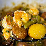 Close-up of shrimp and sausage in the slow cooker with seasoned potatoes.