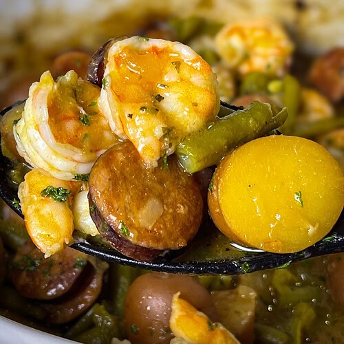 Close-up of shrimp and sausage in the slow cooker with seasoned potatoes.