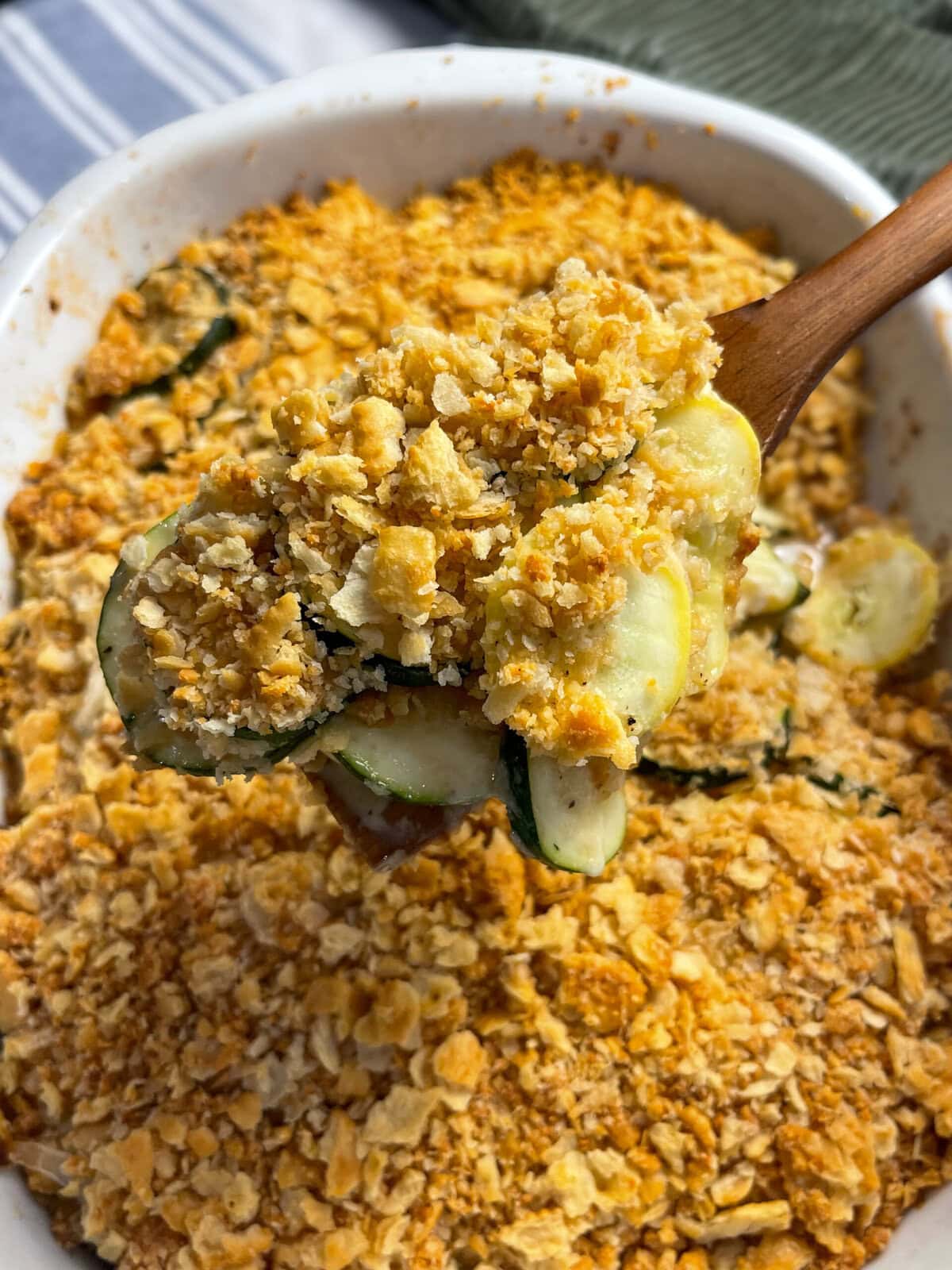 zucchini and yellow squash in a cheesy casserole with a Ritz cracker crumb topping in a 9x13 white baking dish