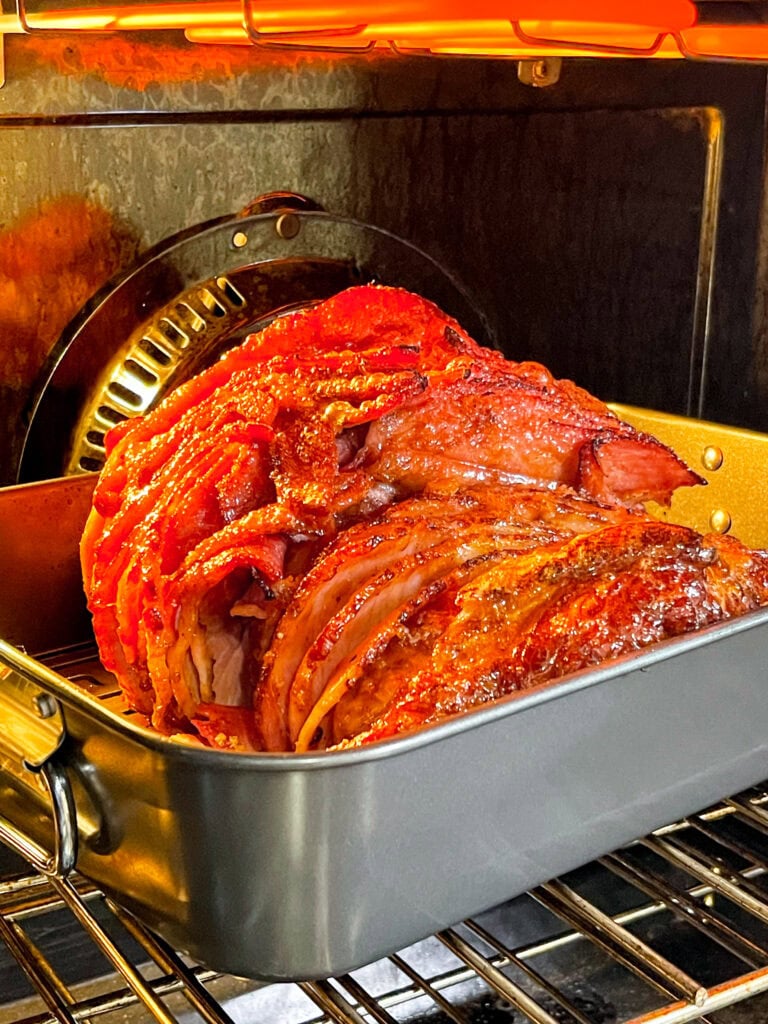 Spiral-sliced ham with caramelized honey glaze on serving platter