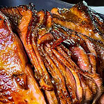 Spiral-sliced ham with caramelized honey glaze on serving platter