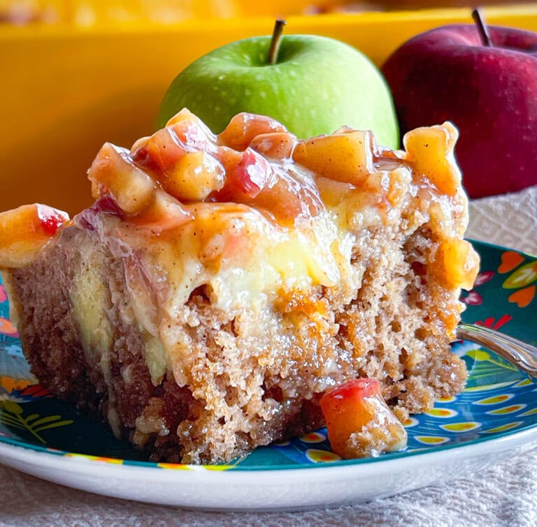 Caramel apple poke cake topped with homemade apple pie filling and caramel drizzle
