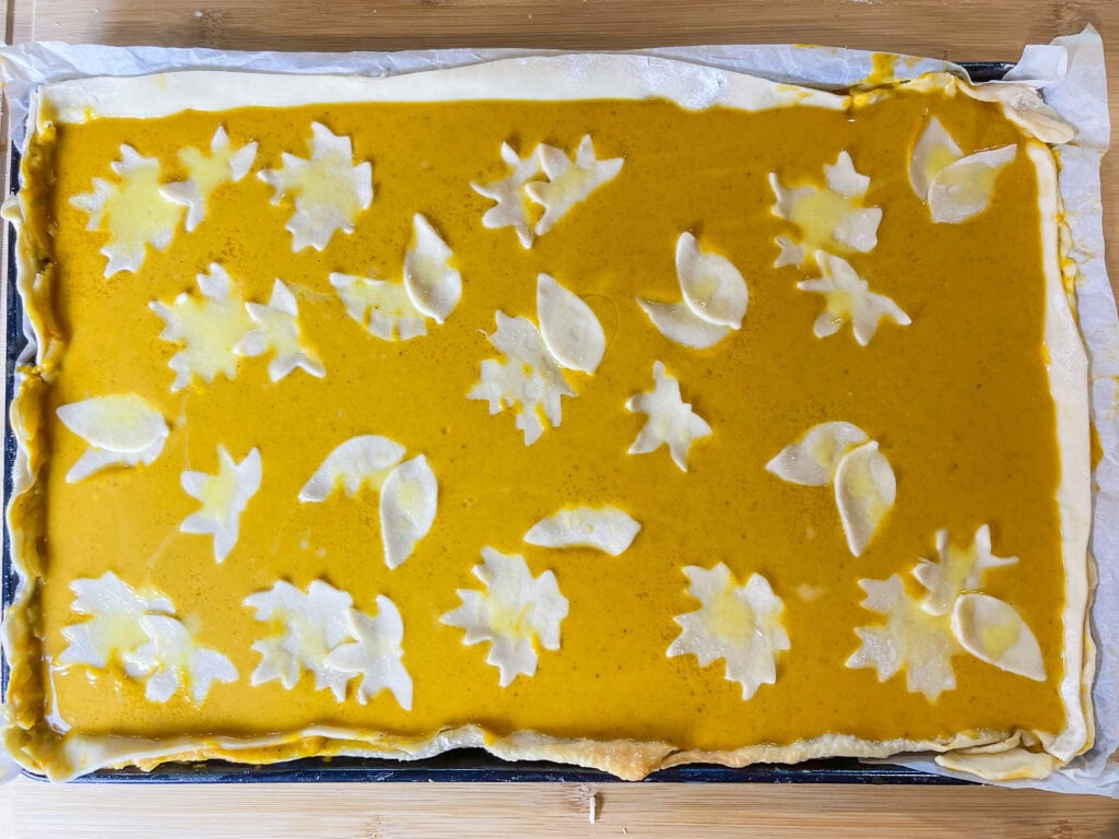 pumpkin pie made in a sheet pan topped with whipped cream