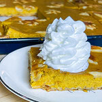 pumpkin pie made in a sheet pan topped with whipped cream