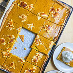 pumpkin pie made in a sheet pan topped with whipped cream