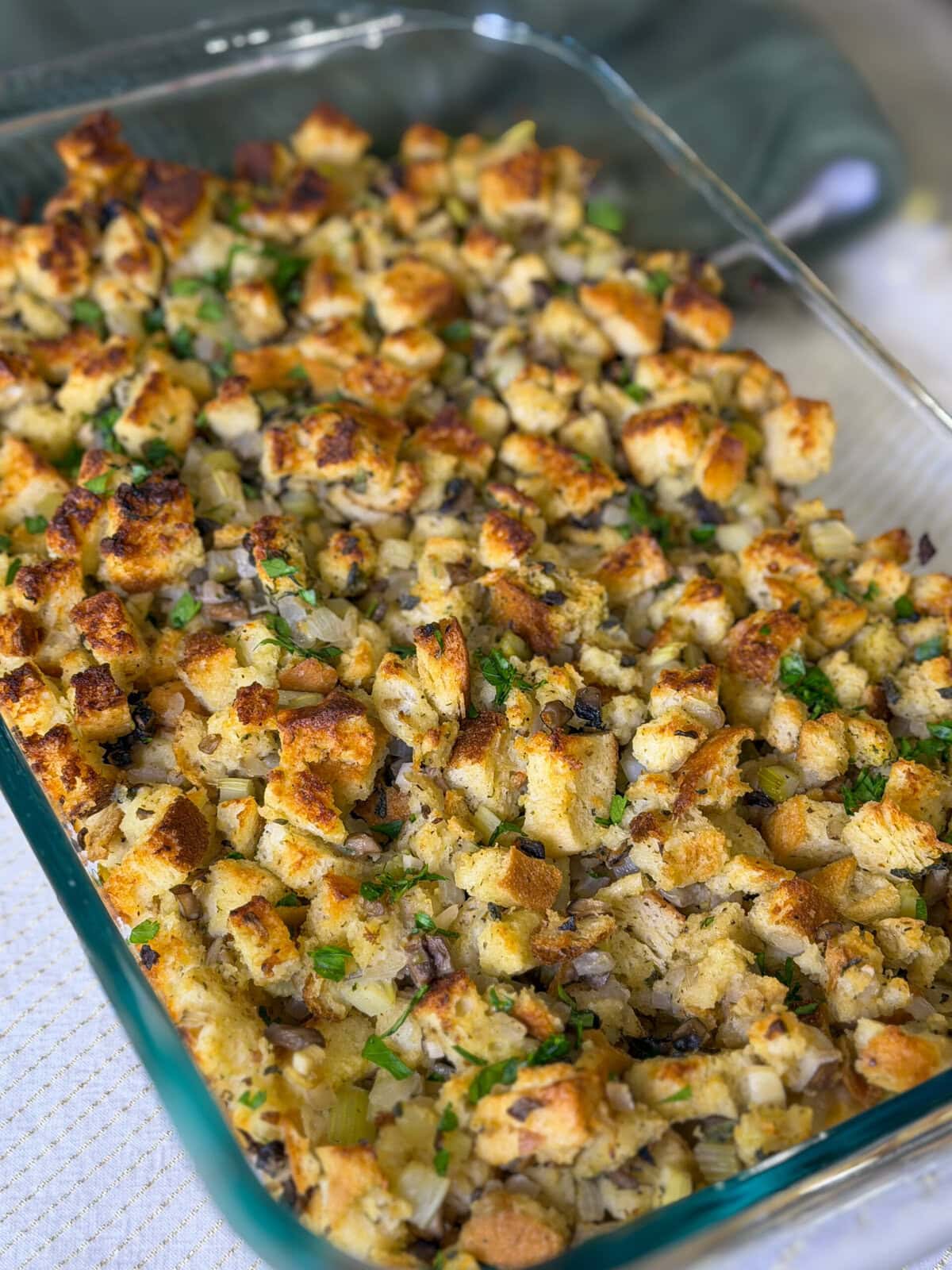 homemade stuffing with celery and mushrooms in a glass baking dish