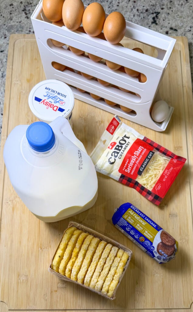ingredients to make breakfast casserole- cheddar cheese, frozen hashbrown patties, eggs, sour cream, turkey breakfast sausage, milk