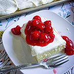 Prepared white cake mix with a white cream cheese frosting topped with cherry pie filling