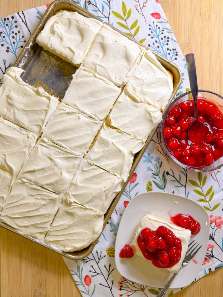 Prepared white cake mix with a white cream cheese frosting topped with cherry pie filling