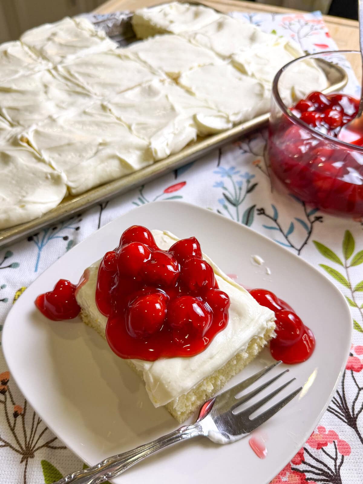 Prepared white cake mix with a white cream cheese frosting topped with cherry pie filling