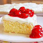 Prepared white cake mix with a white cream cheese frosting topped with cherry pie filling