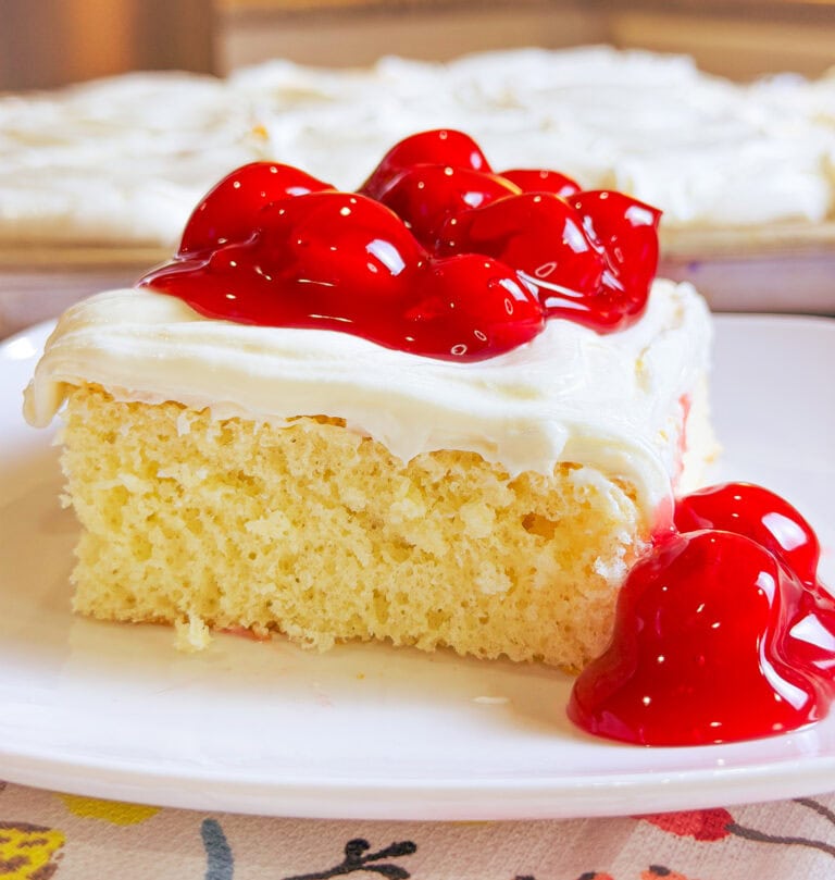 Prepared white cake mix with a white cream cheese frosting topped with cherry pie filling