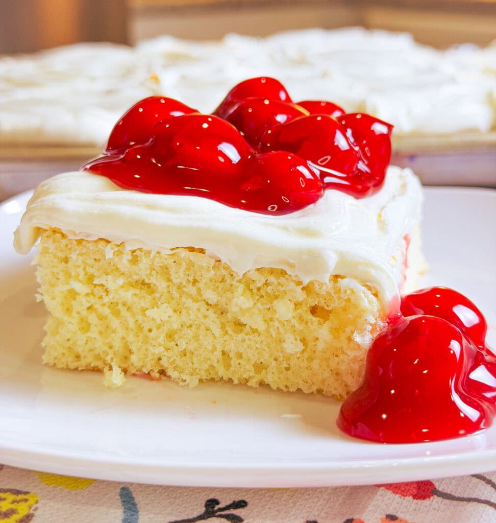 Prepared white cake mix with a white cream cheese frosting topped with cherry pie filling