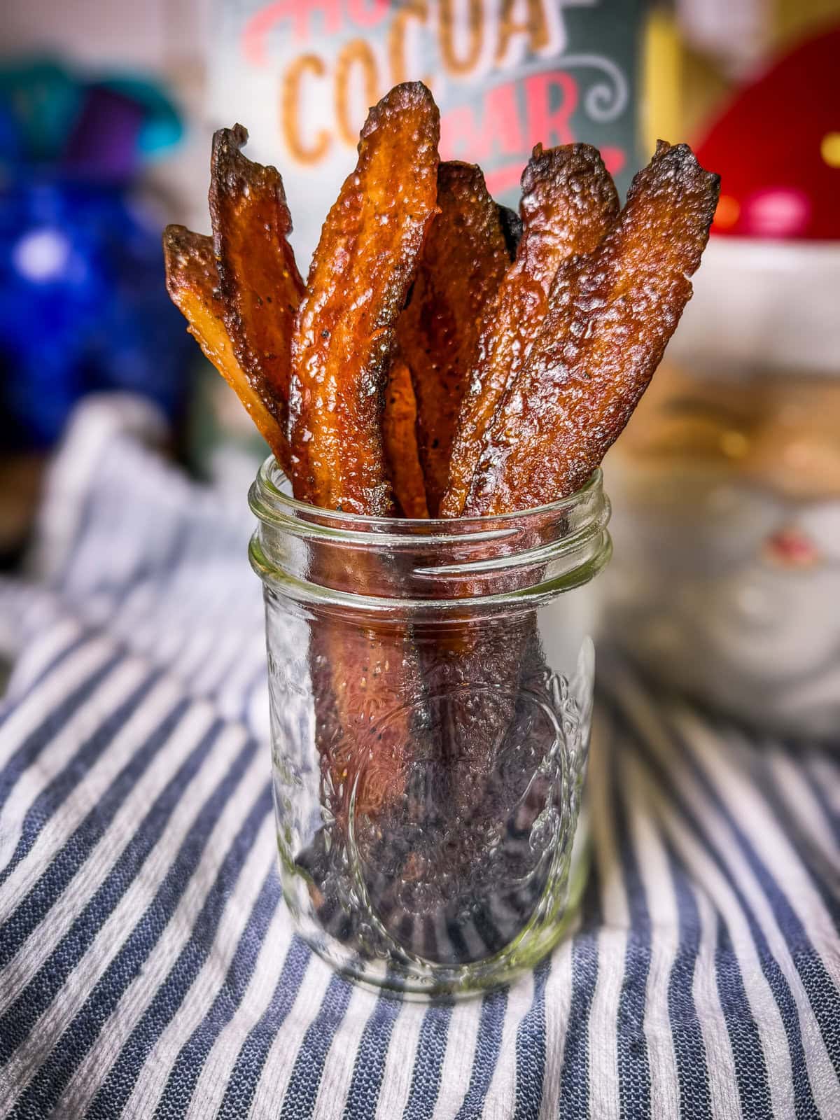 thick sliced bacon glazed with maple syrup and brown sugar, standing upright in a mason jar