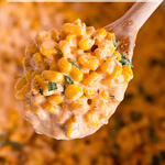 A wooden spoon holds a creamy corn mixture garnished with herbs, with more of the dish blurred in the background. Text reads Crock Pot sweet cream corn and www.stephreallife.com at the bottom.