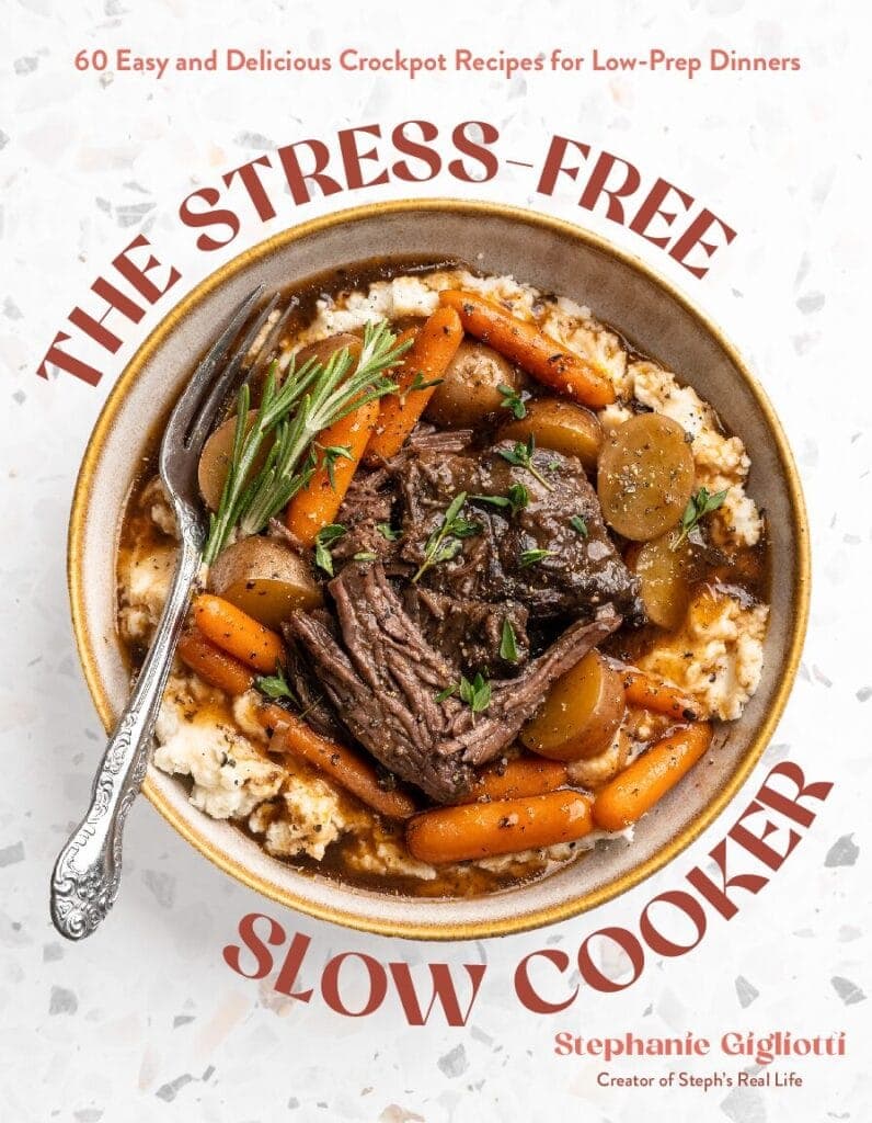 A bowl of pot roast with carrots, potatoes, and gravy over mashed potatoes, garnished with rosemary. The book title The Stress-Free Slow Cooker is displayed, with the author Stephanie Gigliottis name below.