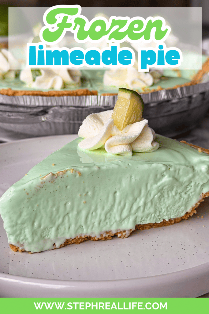 A slice of creamy, light green frozen limeade pie on a plate, topped with whipped cream and a lime wedge, with the rest of the pie in the background.