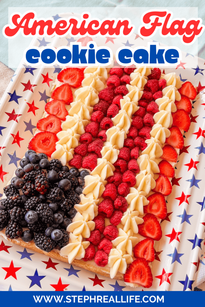 A rectangular cookie cake decorated like the American flag with blackberries, strawberries, raspberries, and piped cream, on a star-patterned tray. Text reads American Flag cookie cake and www.stephreallife.com.