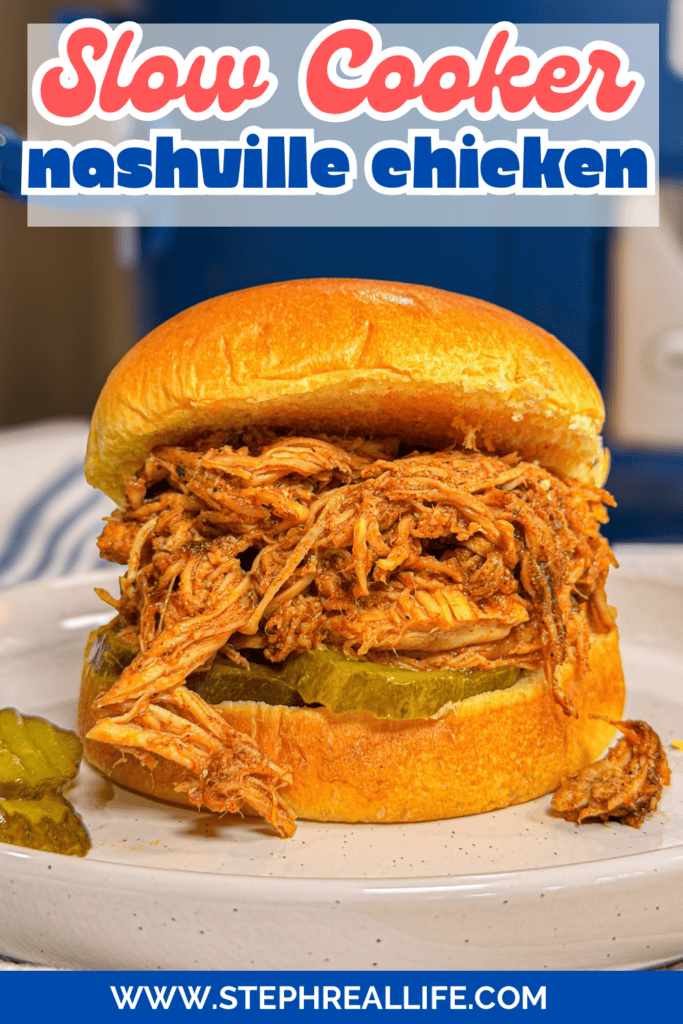 A shredded Nashville chicken sandwich on a bun with pickles, served on a white plate. Text reads Slow Cooker Nashville Chicken and www.stephreallife.com.
