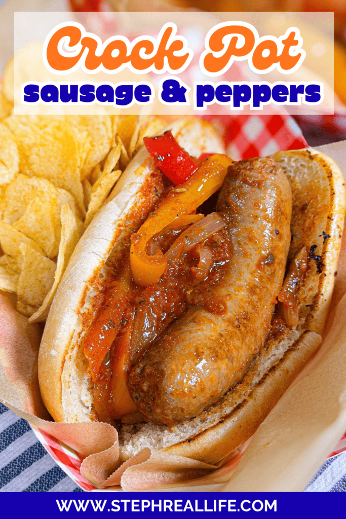 A sausage in a bun with cooked peppers and sauce sits in a basket beside potato chips. Text above reads Crock Pot sausage & peppers. Website URL is visible at the bottom.