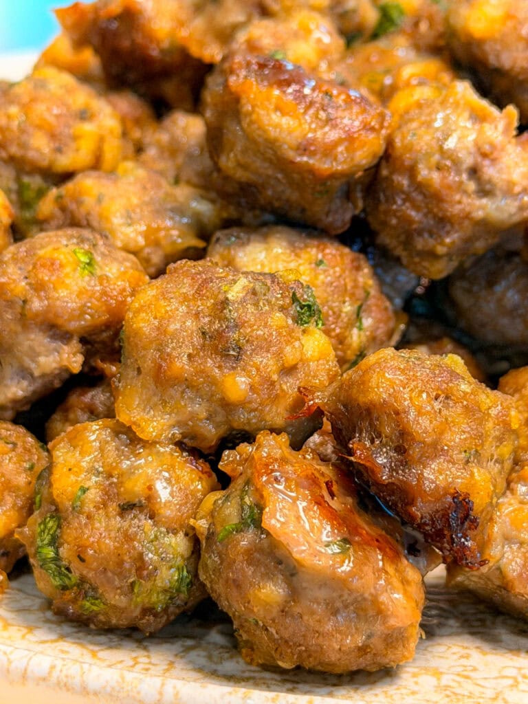 A close-up pile of cooked meatballs with visible flecks of herbs.