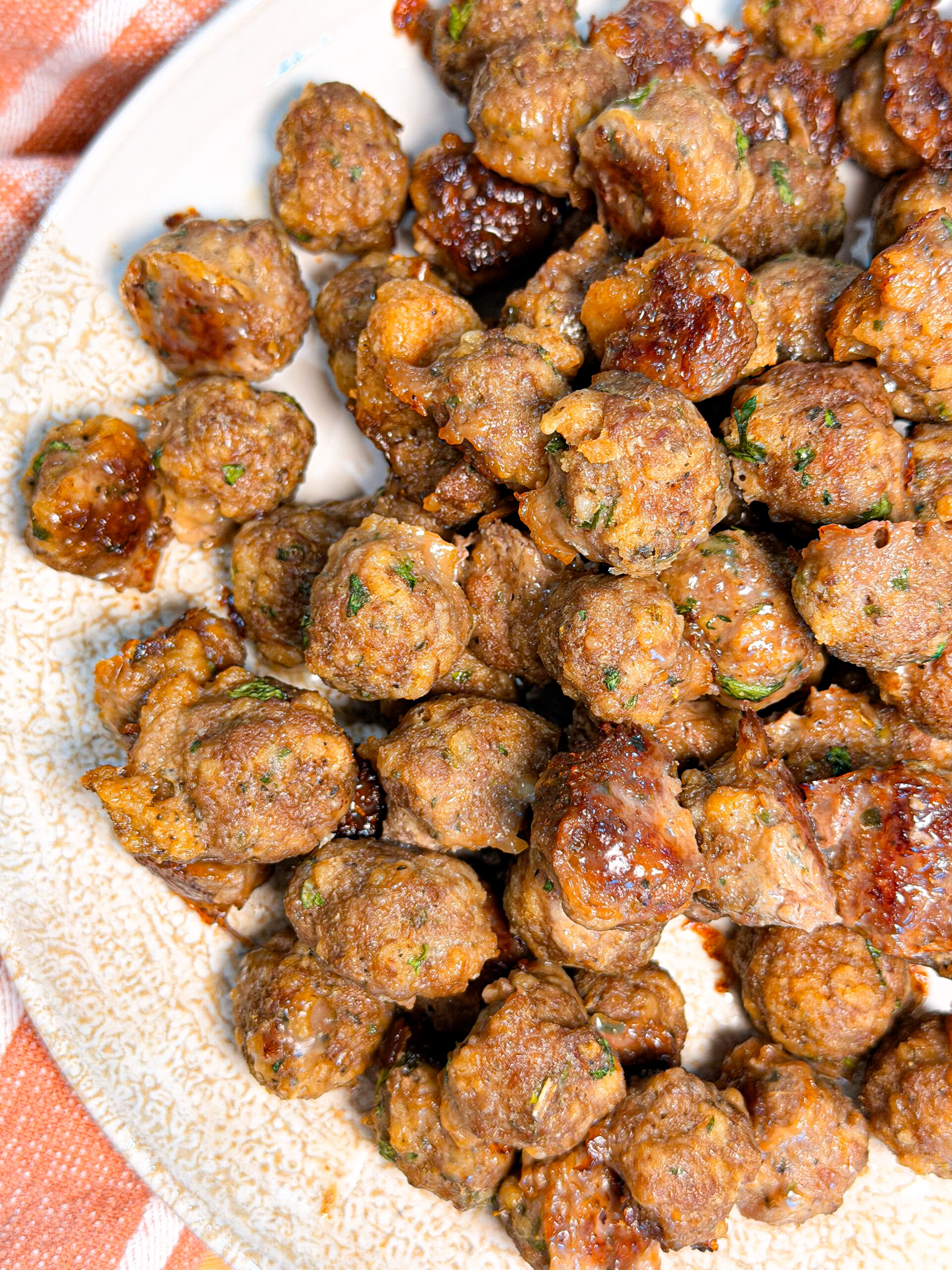 A plate of golden-brown meatballs sprinkled with herbs.