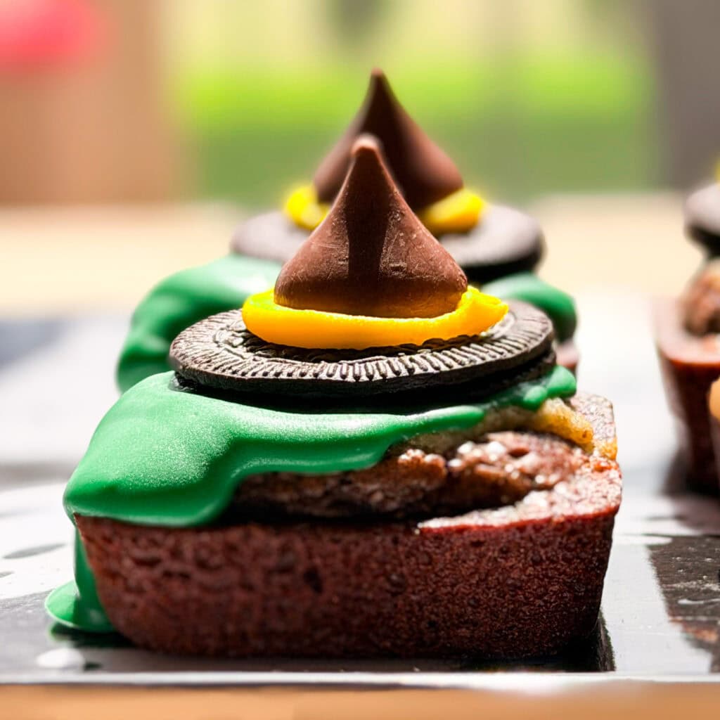 A brownie decorated with green icing, an Oreo cookie, and a chocolate candy kiss to resemble a witchs hat.