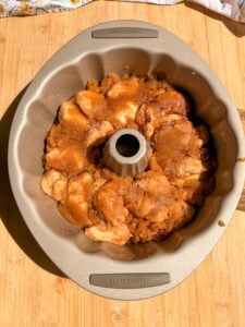 Monkey bread pieces coated in cinnamon sugar inside a round Bundt pan.