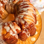 A glazed monkey bread ring on a glass plate.