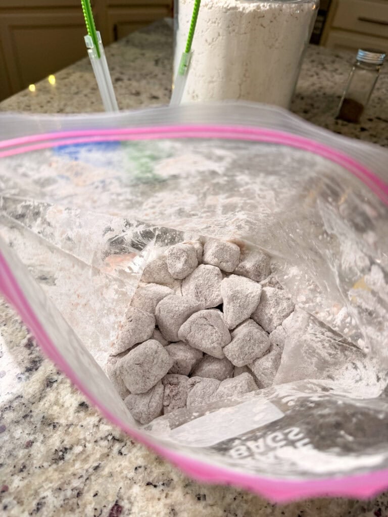 Small, flour-coated dough cubes inside an open plastic storage bag.
